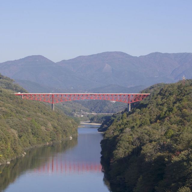 秋晴れの紺碧の空に木曽川の川面と鮮やか赤の城山大橋 