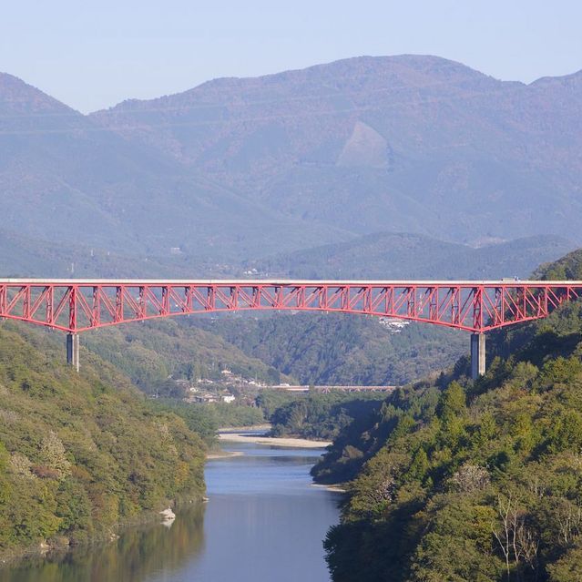 秋晴れの紺碧の空に木曽川の川面と鮮やか赤の城山大橋 