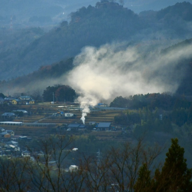 野焼きの煙たなびく幻想的な中津川の風景。