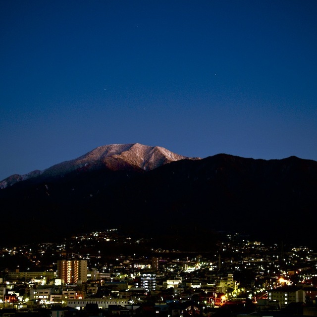 群青の夜空に浮かぶ百名山恵那山と中津川市街の夜景。